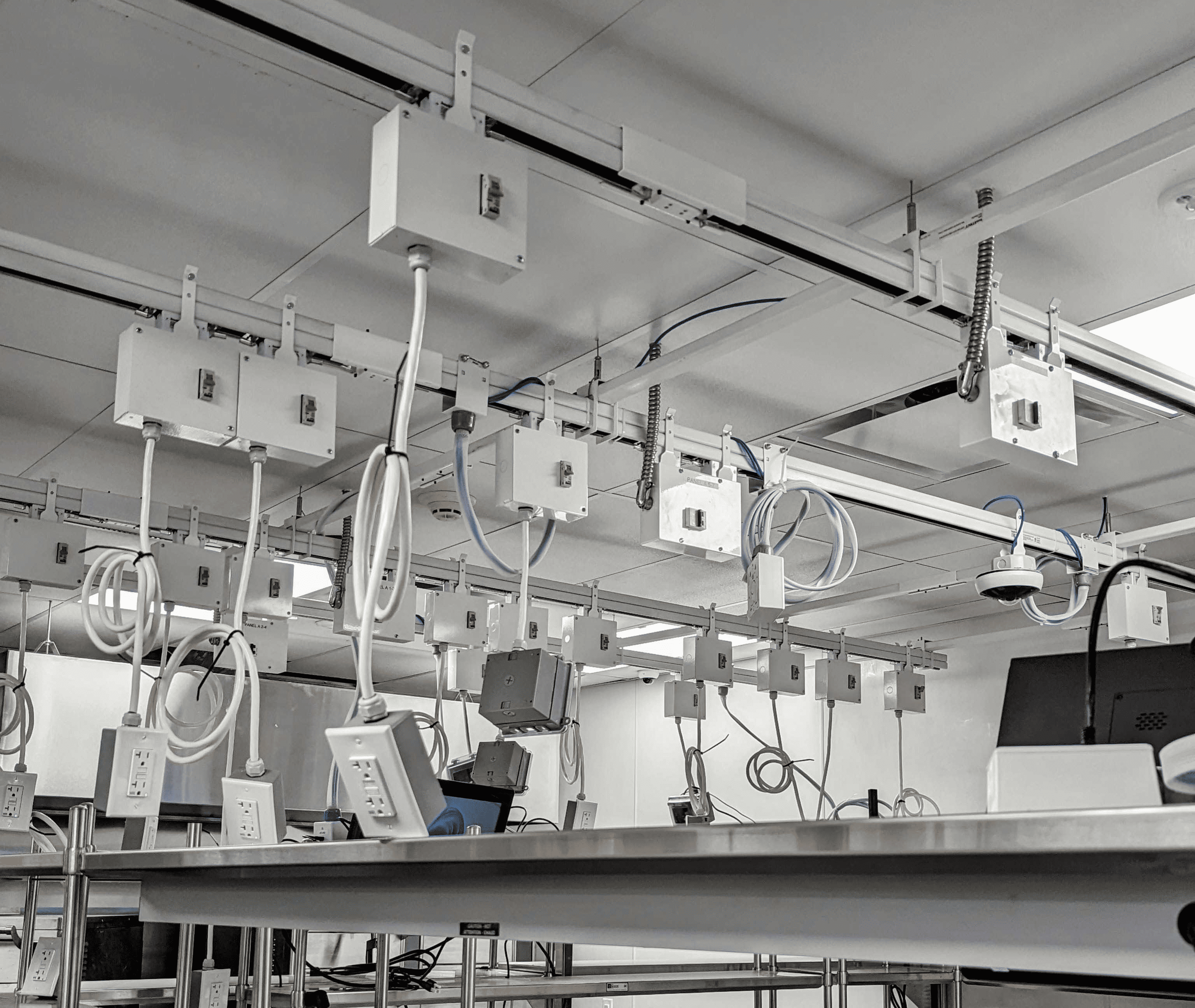 Track busway system in research facility with suspended plug-in power and data drops over lab workstations