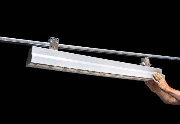 Linear LED light being mounted to Track Busway using brackets for quick installation