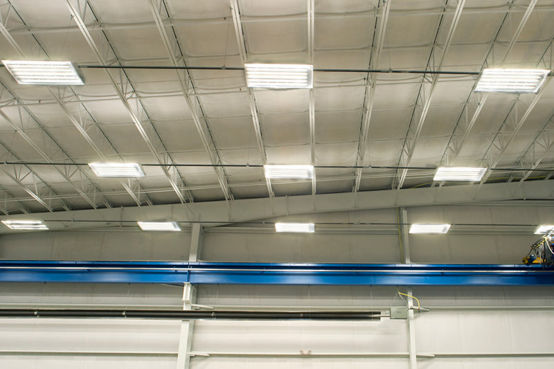 high bay linear lights attached to rows of electrical busway in industrial setting