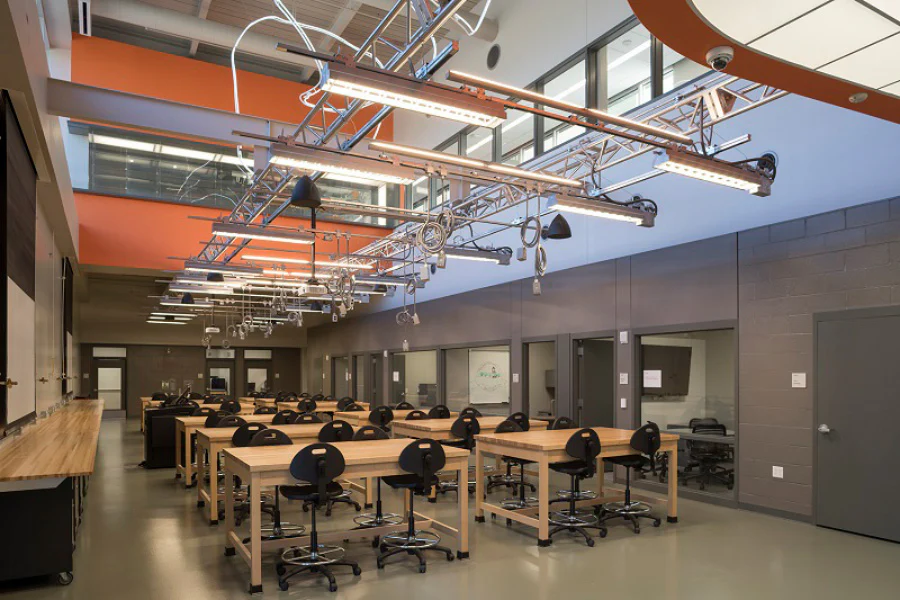 Laboratory workspace with suspended track lighting and overhead power systems above collaborative workstations