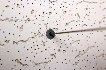 Cable glide protecting a suspension cable passing through an ACT ceiling tile