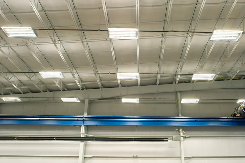 Overhead Track Busway system powering lighting and equipment in a large industrial warehouse
