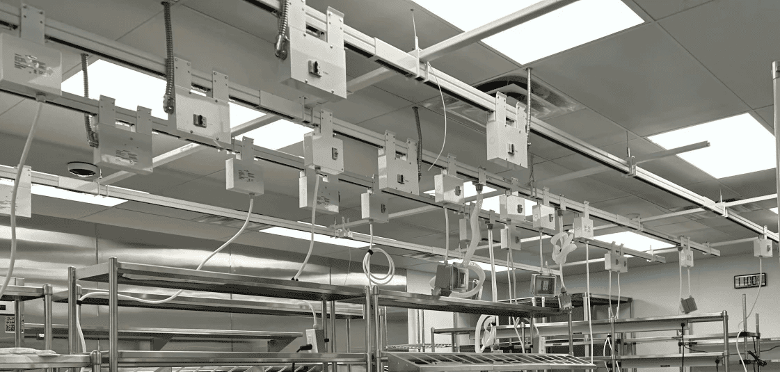Suspended rows of modular track busway in laboratory kitchen providing flexible overhead power for equipment