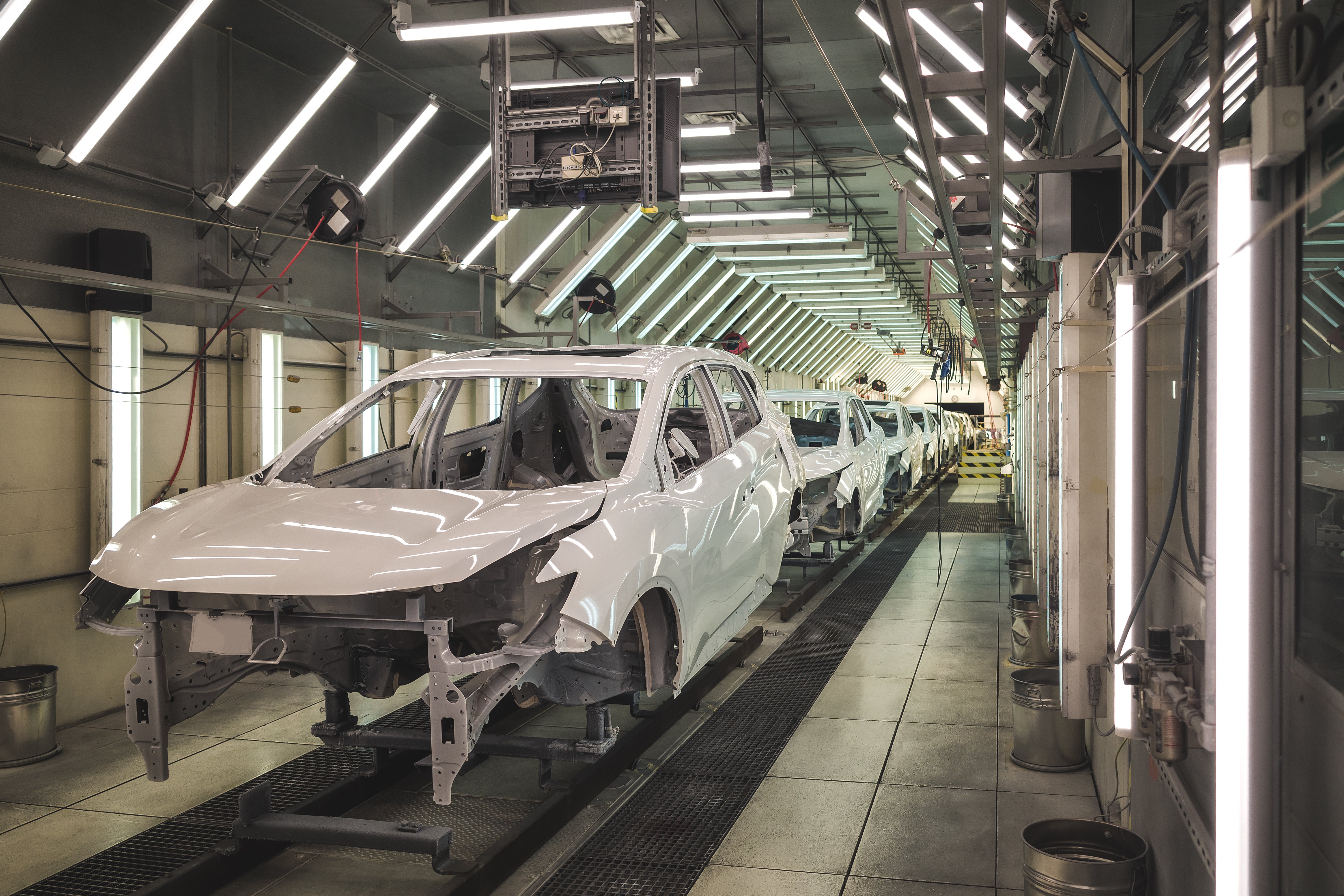Automotive testing and quality control area with overhead power and utility distribution supporting inspection and calibration processes