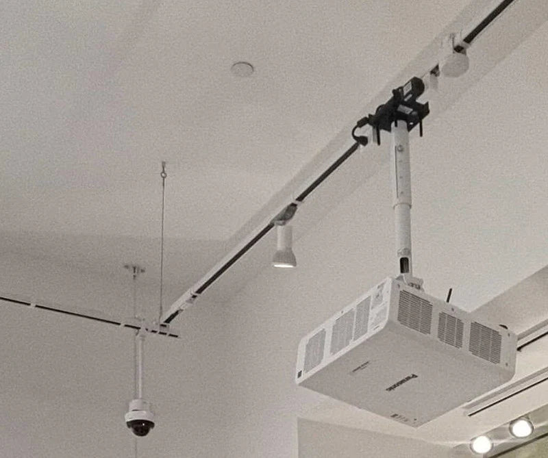 application photo of track busway with accent lighting, projector and security camera